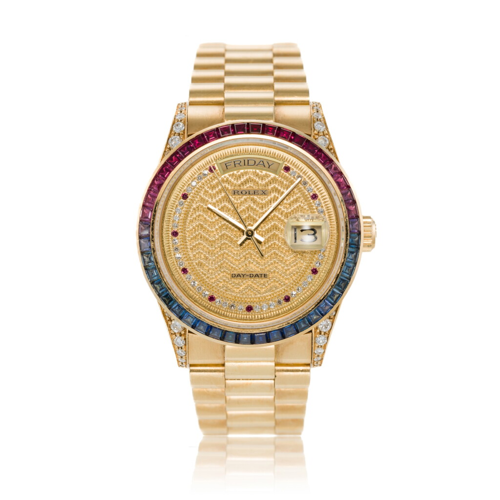 View full screen - View 1 of Lot 76. Reference 18008 Day-Date | A yellow gold and diamond-set automatic wristwatch with day, date and ruby and sapphire-set bezel, Circa 1986.