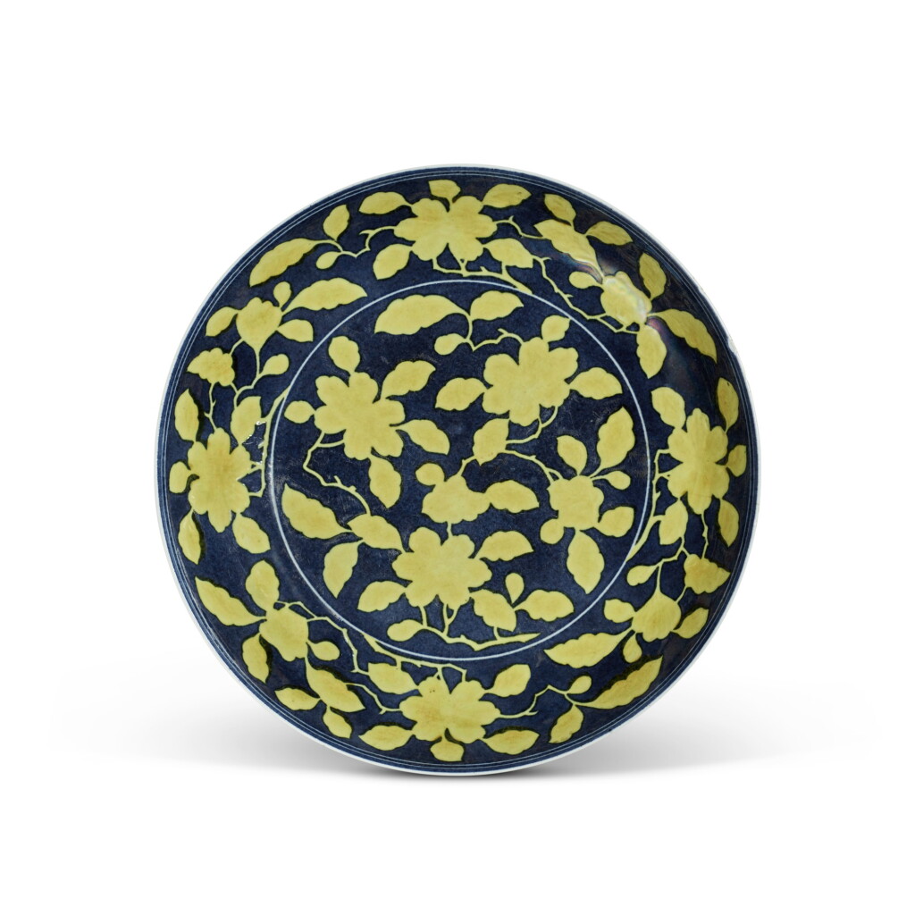 View full screen - View 1 of Lot 117. A yellow reserve blue-ground 'gardenia' dish, Mark and period of Yongzheng | 清雍正 灑藍地黃彩梔子花紋盤 《大清雍正年製》款.