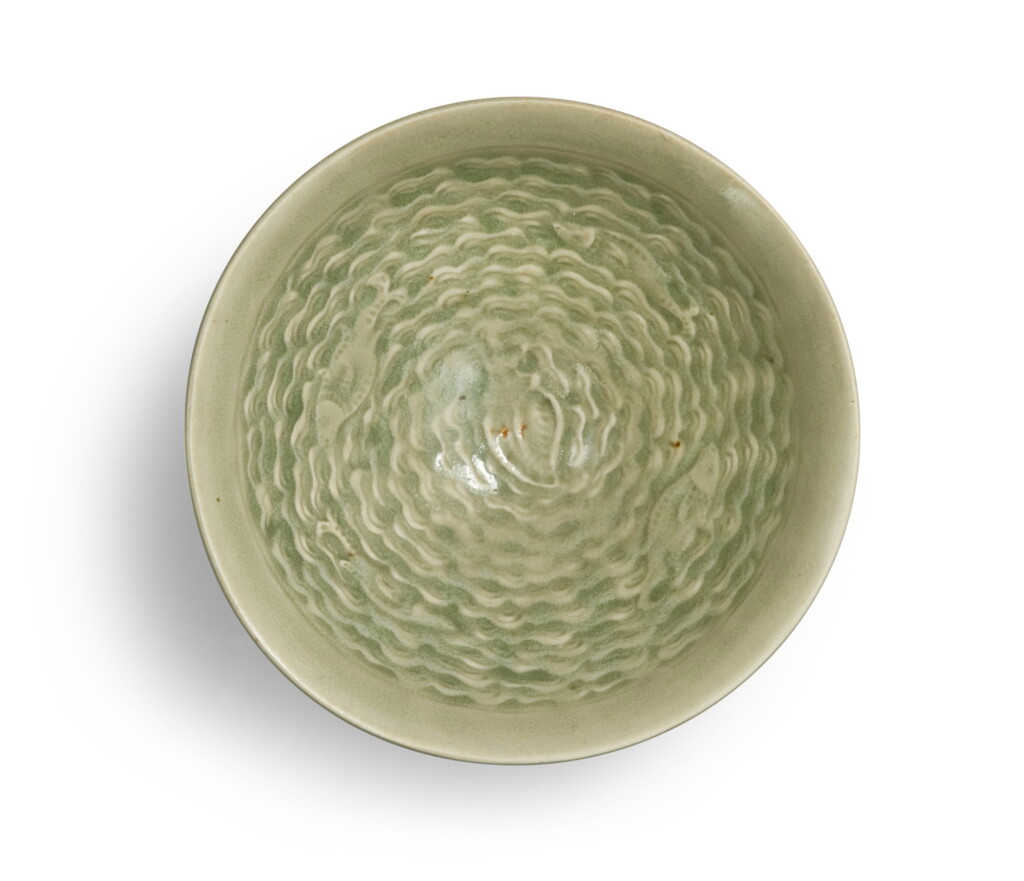 View full screen - View 1 of Lot 401. A molded 'Yaozhou' celadon-glazed 'fish and wave' bowl, Northern Song dynasty | 北宋 耀州窰青釉印水波游魚紋盌.