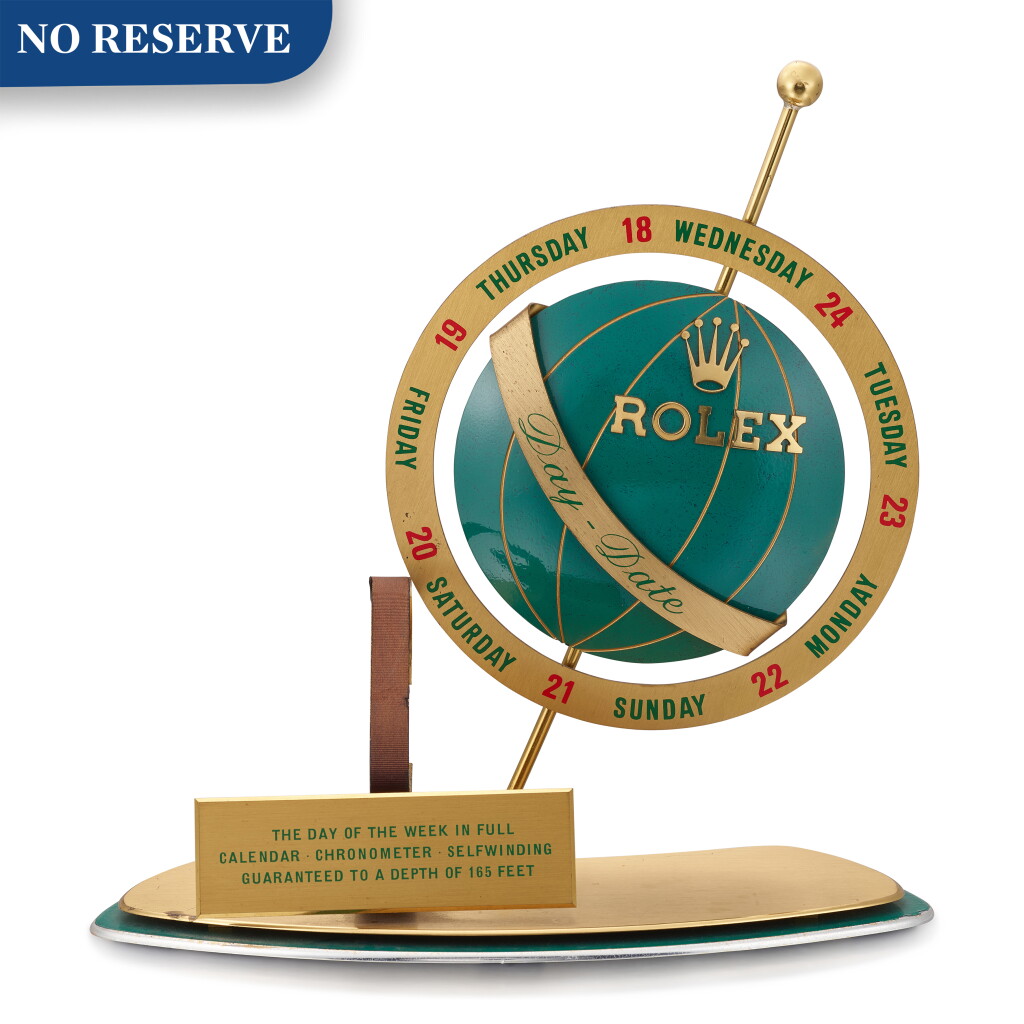 View full screen - View 1 of Lot 8005. ROLEX | DAY OF THE WEEK A GILT BRASS AND GREEN ENAMEL RETAILER'S WINDOW DISPLAY, CIRCA 1960.