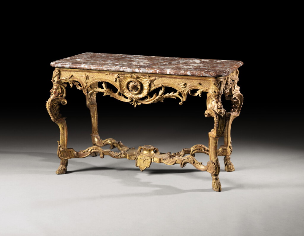 View full screen - View 1 of Lot 146. A RÉGENCE CARVED GILTWOOD CONSOLE TABLE | TABLE CONSOLE À TÊTES DE SATYRE EN BOIS SCULPTÉ ET DORÉ D'ÉPOQUE RÉGENCE.