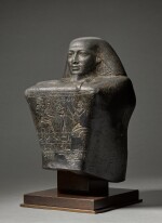 An Egyptian Basalt Block Statue of Pamiu (‘the Cat’), Prophet of Amun at Karnak, Late 25th Dynasty, circa 690-656 B.C.