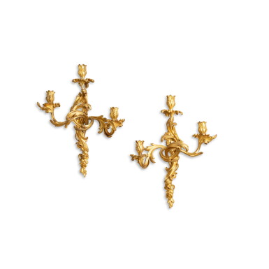 View full screen - View 1 of Lot 432. A pair of Louis XV gilt-bronze three-light wall lights, circa 1750, in the style of Jacques Caffieri | Paire d'appliques à trois lumières en bronze doré d'époque Louis XV, vers 1750, dans le style de Jacques Caffieri.