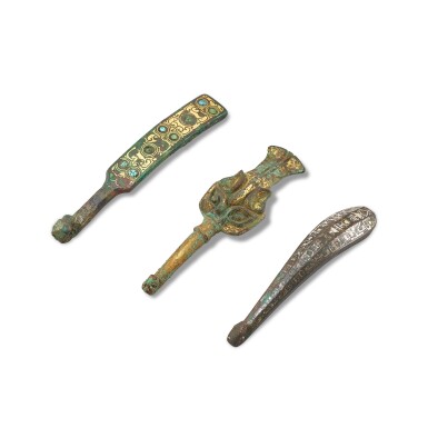 View full screen - View 1 of Lot 851. A hardstone and gold-inlaid bronze belt hook, a gilt-bronze 'mythical beast' belt hook and a gold and silver-inlaid bronze belt hook, Eastern Zhou dynasty, Warring States period 東周戰國時期 銅錯金嵌寶帶鉤、鎏金銅獸面紋帶鉤 及 銅錯金銀帶鉤.
