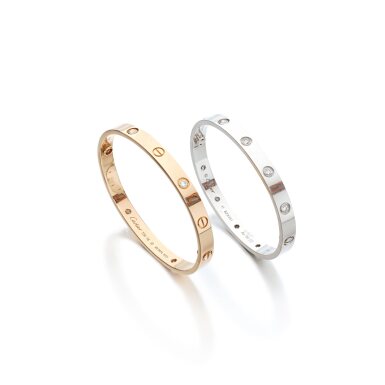 View full screen - View 1 of Lot 910. Two gold and diamond bangles, 'Love'.