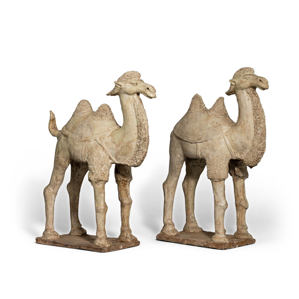 View full screen - View 1 of Lot 647. A pair of straw-glazed pottery camels, Tang dynasty | 唐 白釉駱駝一對.