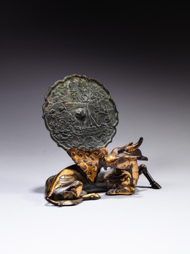 View full screen - View 1 of Lot 69. A parcel-gilt bronze 'xiniu' mirror stand and an archaic bronze mirror the stand, Ming dynasty, the mirror, 12th - 14th century | 明 銅局部鎏金犀牛望月鏡架 及 十二至十四世紀銅龍紋鏡.