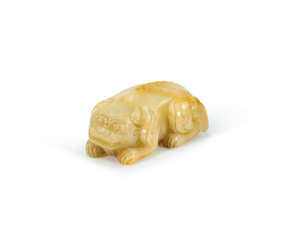 View full screen - View 1 of Lot 2125. A celadon and russet jade figure of a mythical beast Qing dynasty | 清 青白玉瑞獸把件 .