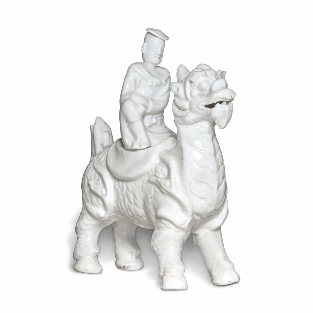 View full screen - View 1 of Lot 417. A 'Dehua' 'Qilin and rider' group, Qing dynasty, 18th century | 清十八世紀 德化白釉仙人騎麒麟像.