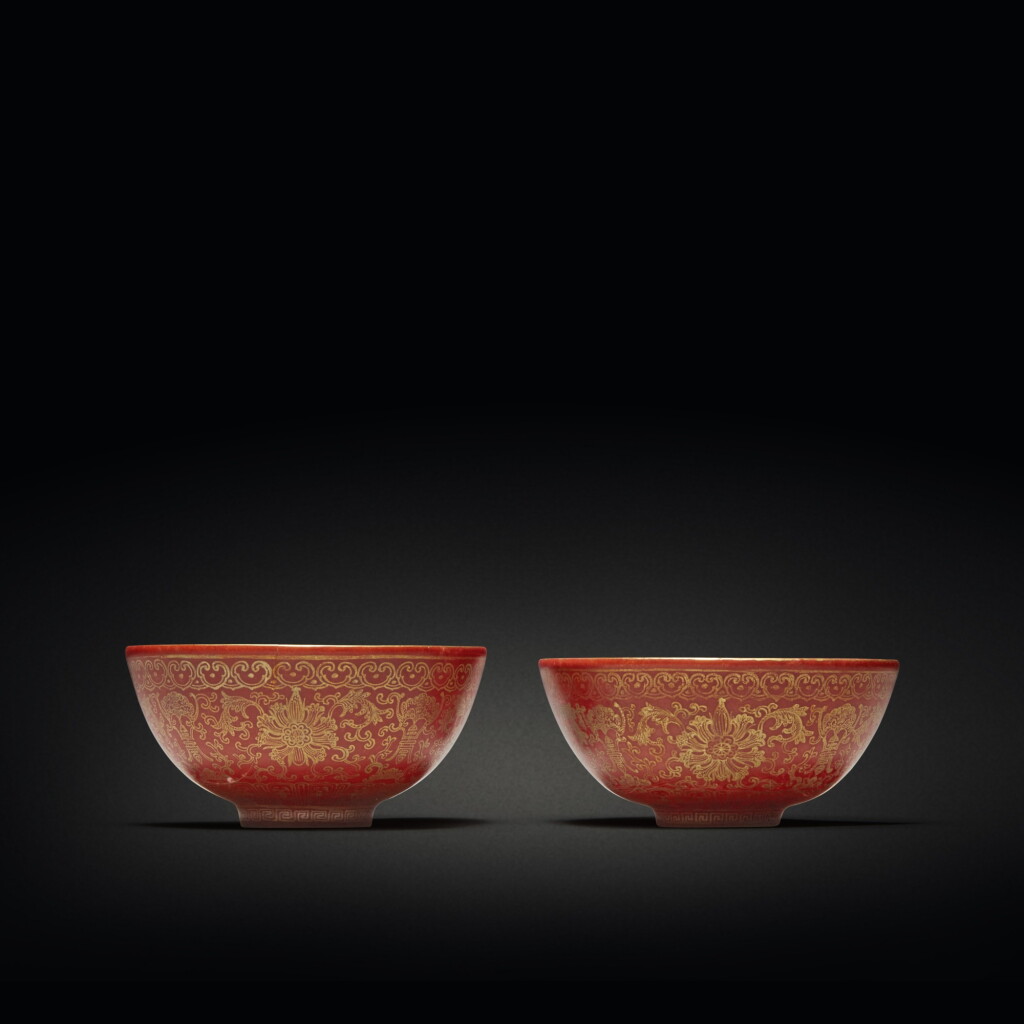 View full screen - View 1 of Lot 582. A pair of coral-ground gilt-decorated 'lotus' wine cups, Qing dynasty, 19th century | 清十九世紀 珊瑚紅地描金纏枝蓮福壽紋小盃一對 《大清乾隆年製》仿款.