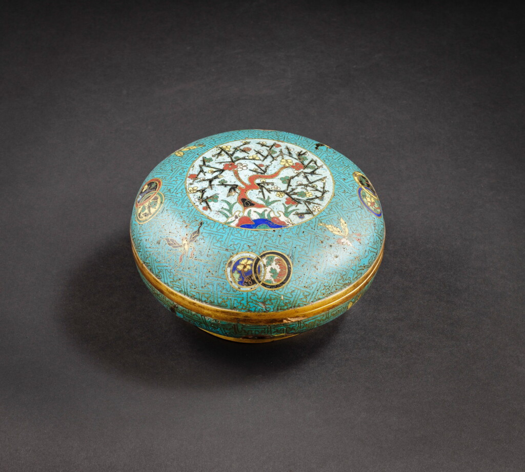 View full screen - View 1 of Lot 82. A gilt-bronze and cloisonné enamel 'prunus and butterflies' box and cover, Qing dynasty, first half of the 19th century | 清十九世紀上半葉 掐絲琺瑯開光梅樹花開紋蓋盒.