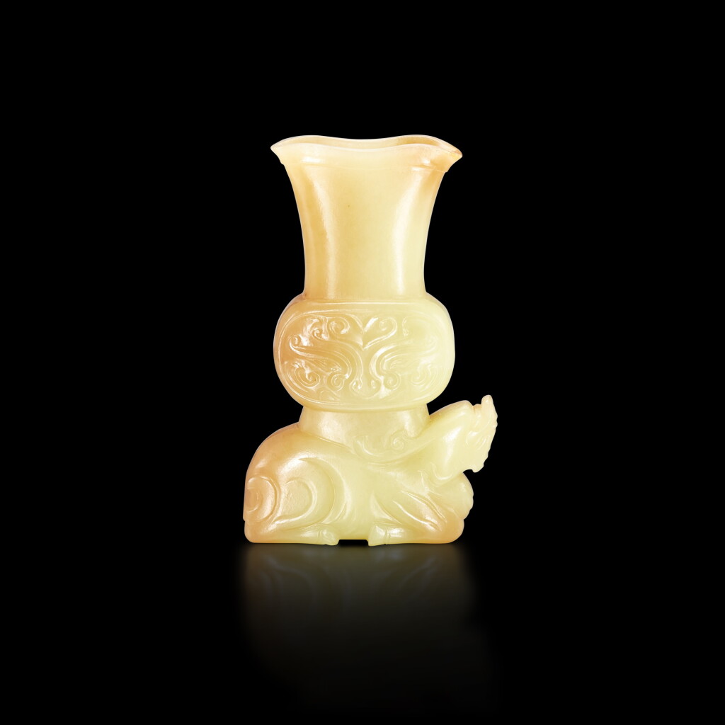 View full screen - View 1 of Lot 423. A small yellow and russet jade archaistic 'mythical beast' gu vase, Qing dynasty, 18th - 19th century 清十八至十九世紀 黃玉仿古瑞獸饕餮紋花觚.