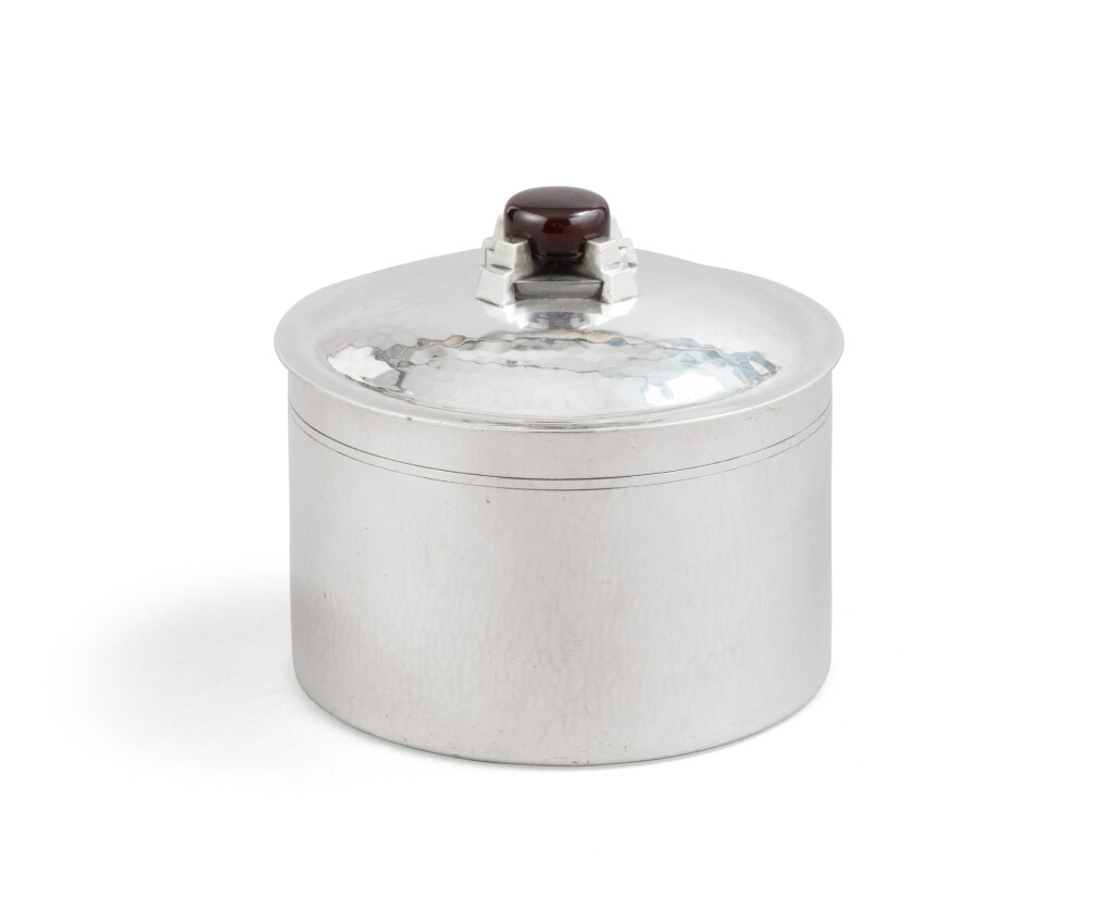 View full screen - View 1 of Lot 19. A French circular silver biscuit box, with bakelite cover finial, Georges Lecomte, Paris, circa 1925 | Boîte à biscuits ronde en argent martelé, la prise en bakélite, par Georges Lecomte, Paris, vers 1925.