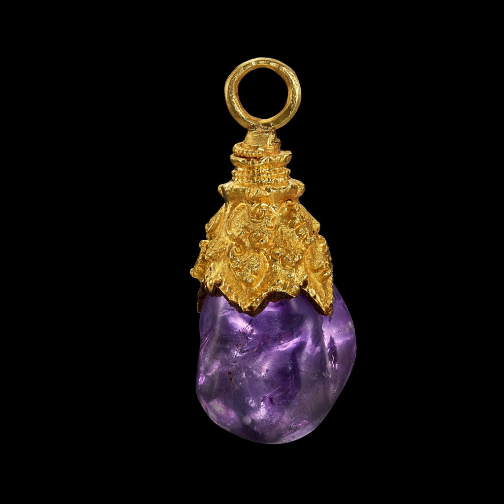 View full screen - View 1 of Lot 1006. A gold pendant with amethyst pebble Java, Indonesia, 7th - 12th century | 印尼爪哇 七至十二世紀 金嵌紫水晶吊飾.