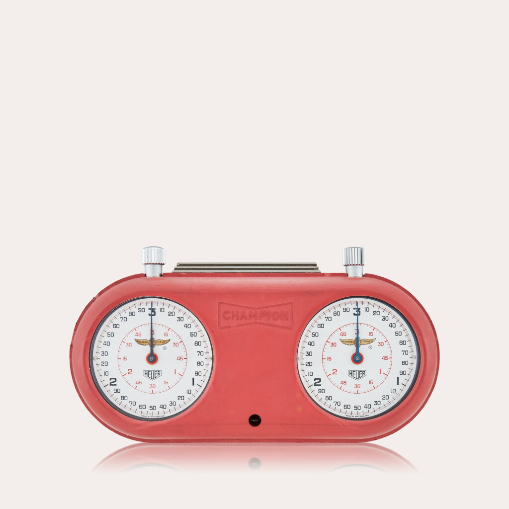 View full screen - View 1 of Lot 125. Reference 503.202 Indianapolis Motor Speedway | Two stainless steel stopwatches with fitted rubber Champion Spark Plugs case, 1970.
