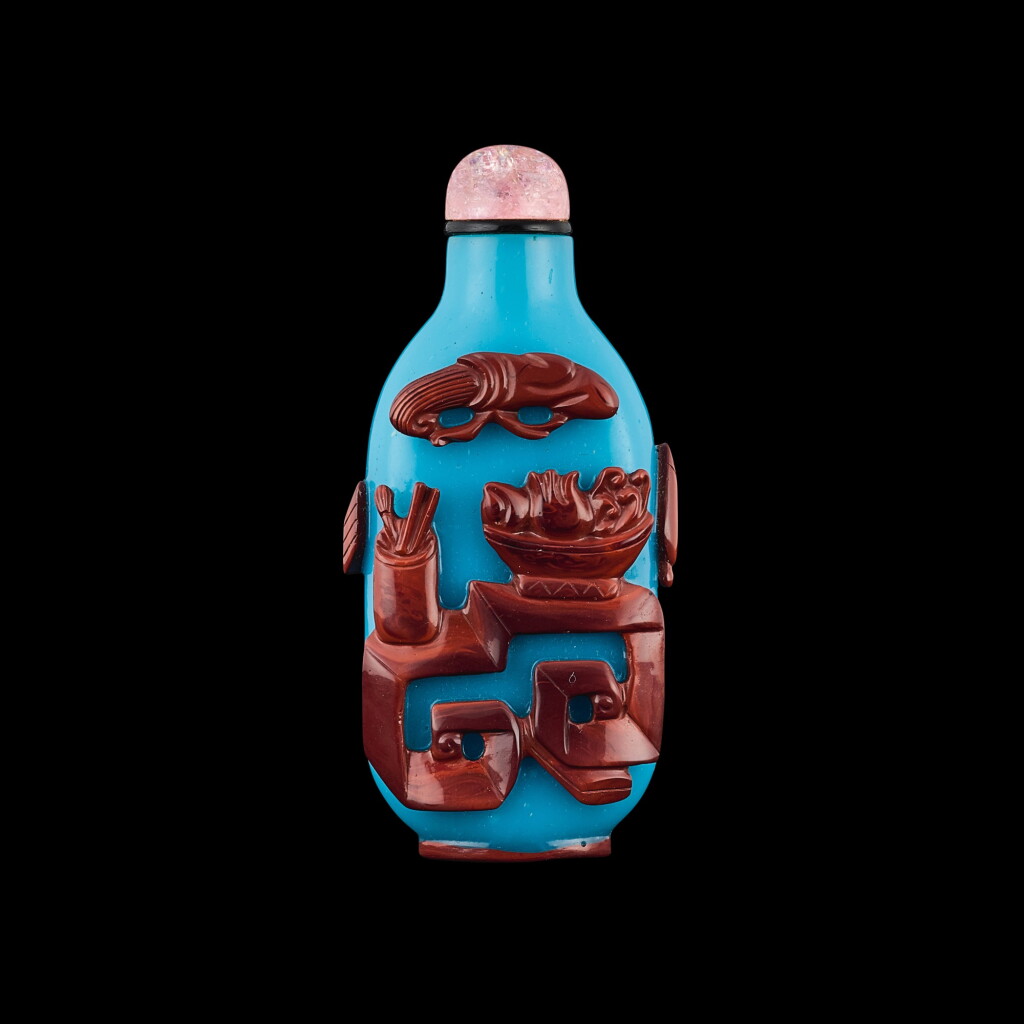 View full screen - View 1 of Lot 1016. A cinnabar-red overlay turquoise-blue glass 'antiques' snuff bottle, Qing dynasty, 19th century | 清十九世紀 翠藍地套朱紅料博古圖鼻煙壺.