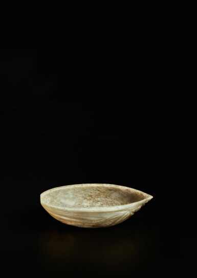 View full screen - View 1 of Lot 474. A rare inscribed brown jade 'peach seed' vessel, Ming / early Qing dynasty | 明 / 清初 玉雕半桃核式盃.