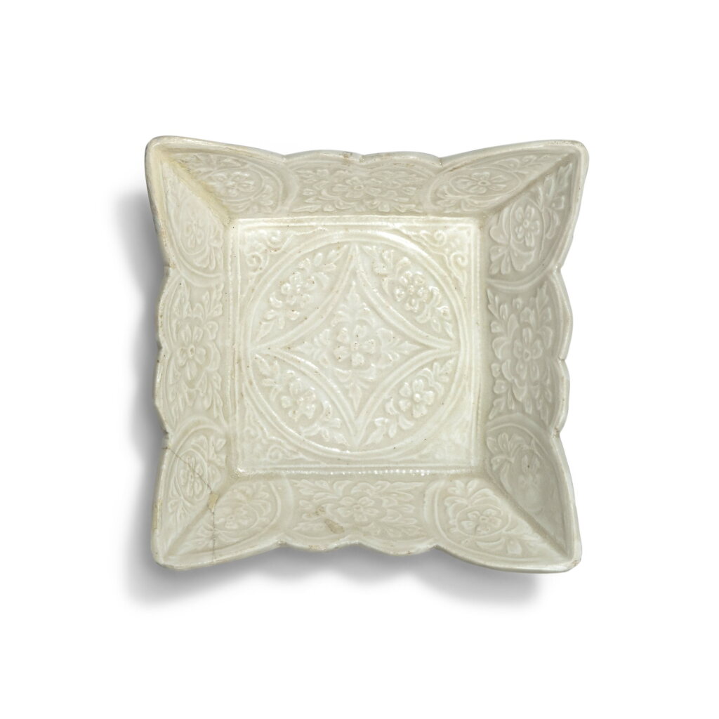 View full screen - View 1 of Lot 25. A molded white-glazed 'floral' square dish, Liao dynasty | 遼 白釉印花花口方盤.