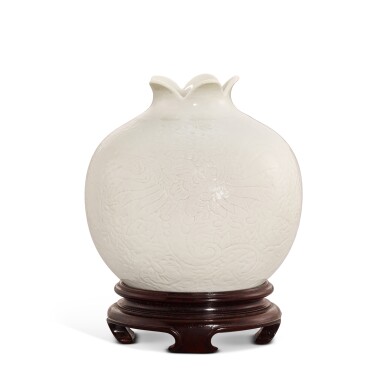 View full screen - View 1 of Lot 319. A soft-paste white porcelain carved 'pomegranate' waterpot, Qing dynasty, Qianlong period 清乾隆 漿胎白瓷刻鳳紋石榴尊.