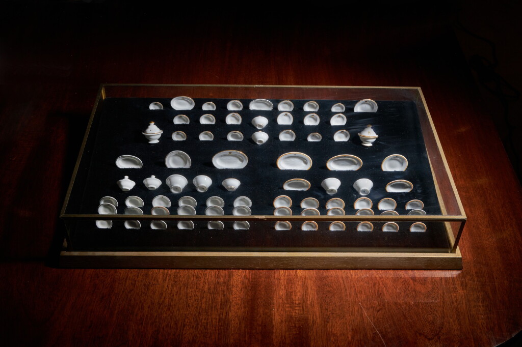 View full screen - View 1 of Lot 1. "Queen Mary's Dolls' House", three miniature Royal Doulton Dinner services, set in a bespoke display case, circa 1922.