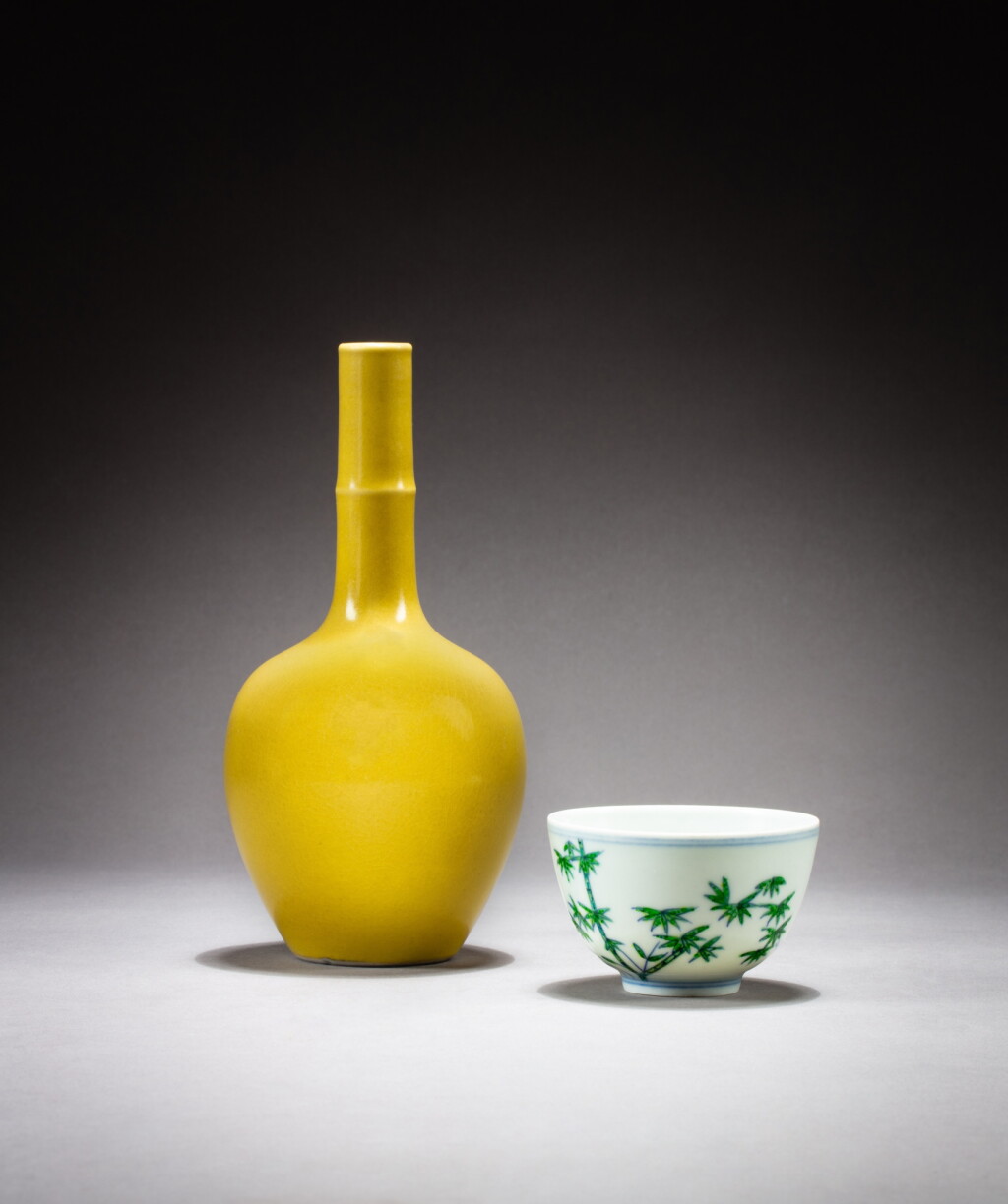 View full screen - View 1 of Lot 71. A small yellow-glazed bottle vase and a 'bamboo' wucai cup, 19th-20th century | 十九至二十世紀 黃釉長頸瓶 及 五彩竹菊紋小盃.