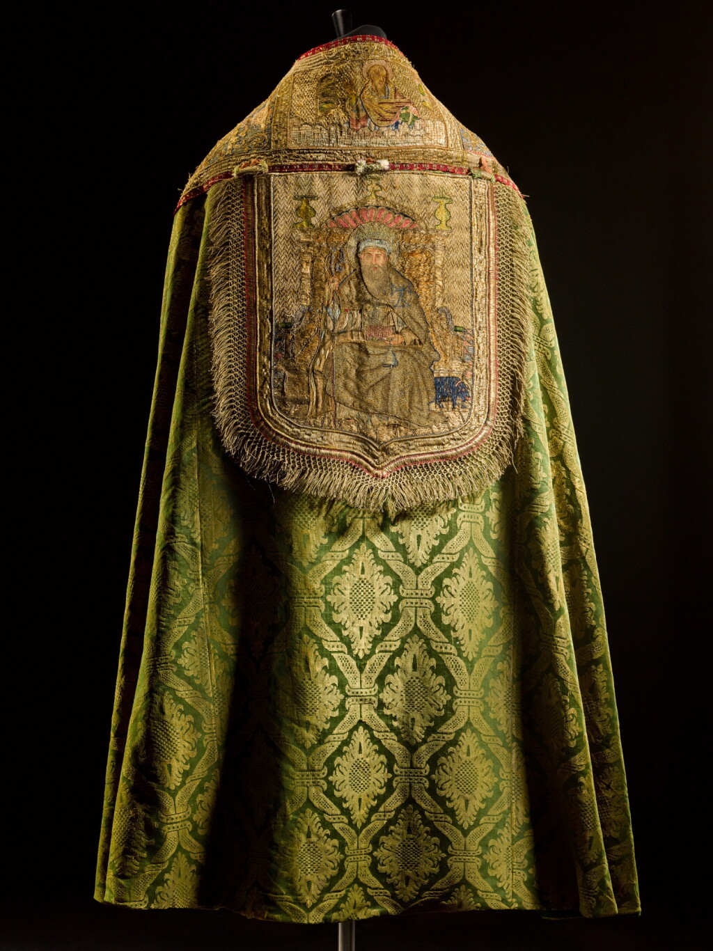 View full screen - View 1 of Lot 236. A cope of gold and green silk lampas, with embroidered and metal-thread orphrey panel, Italian, late 16th or early 17th century.
