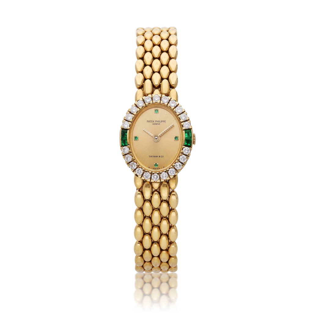 View full screen - View 1 of Lot 109. Reference 4752/23 | Retailed by Tiffany & Co.: A yellow gold, diamond and emerald-set bracelet watch, Circa 1980.