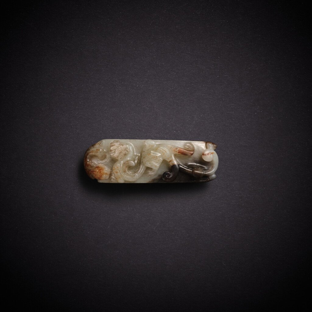 View full screen - View 1 of Lot 5816. A greyish-white jade 'tiger' scabbard slide, Han dynasty | 漢 灰白玉虎紋劍璏.