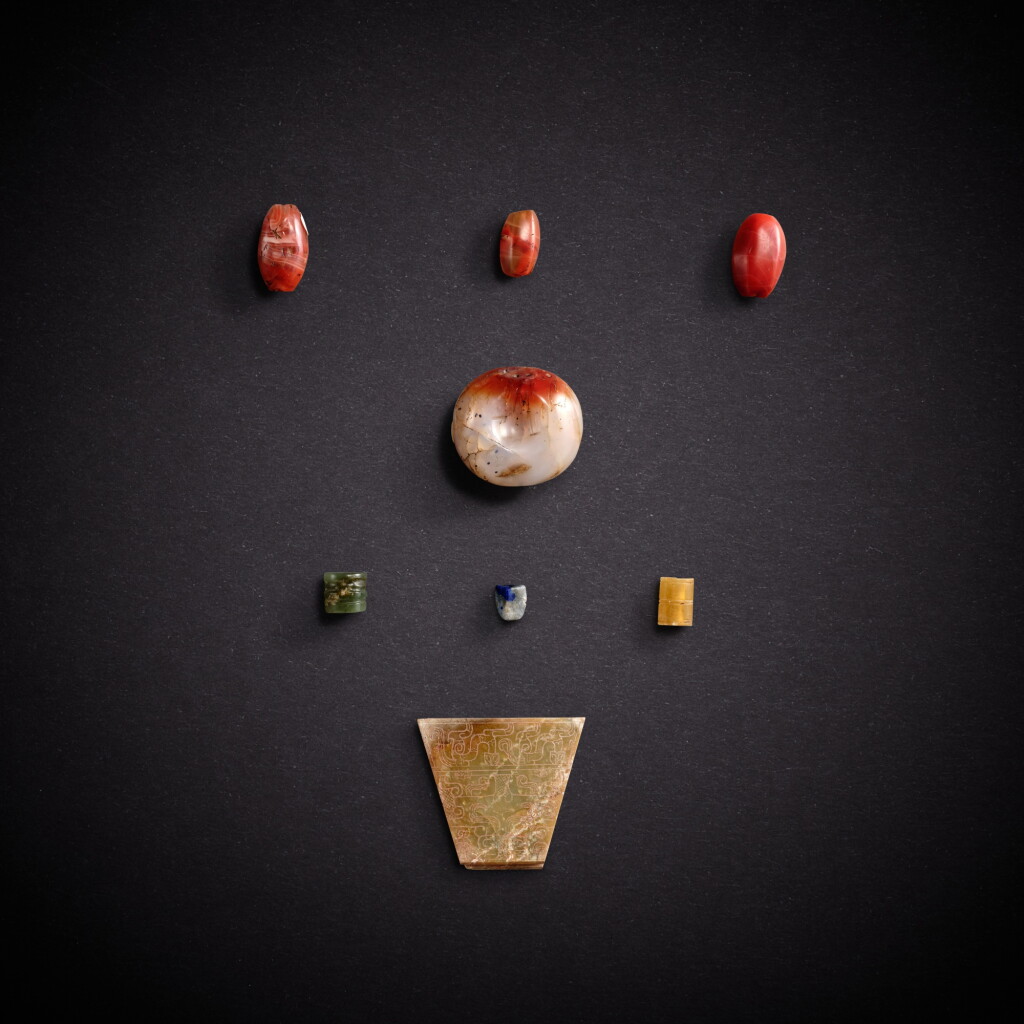 View full screen - View 1 of Lot 7859. Seven jade and hardstone beads and a jade 'mask' pendant, Eastern Zhou dynasty | 東周 玉石珠飾七件及青玉獸面紋珮.