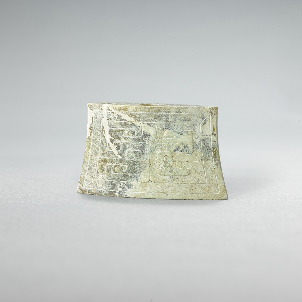 View full screen - View 1 of Lot 742. A celadon jade 'mask' scabbard chape, Western Han dynasty | 西漢 青玉獸面紋劍珌.