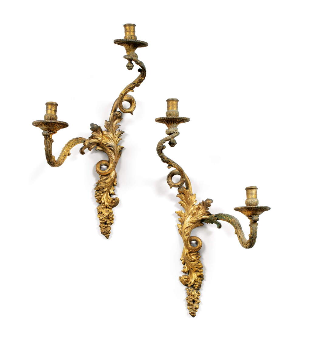 View full screen - View 1 of Lot 24. A pair of French Régence gilt-bronze two-lights wall-lights, circa 1725, after a model by André-Charles Boulle.