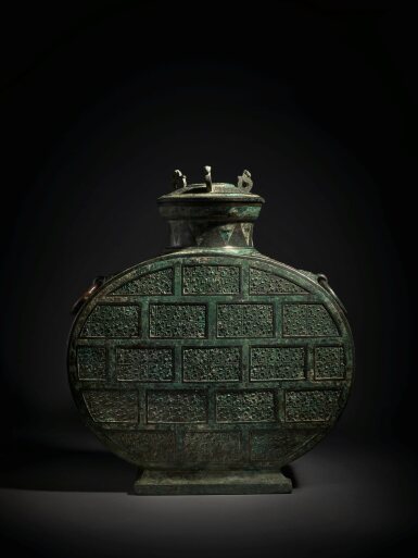 View full screen - View 1 of Lot 25. A rare copper-inlaid bronze wine vessel and cover (Bianhu), Eastern Zhou dynasty, Warring States period | 東周 戰國 青銅錯銅交龍紋扁壺.