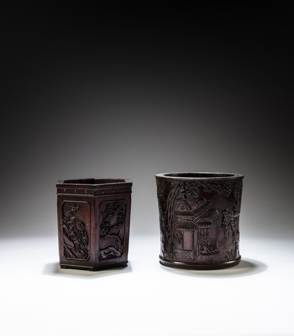 View full screen - View 1 of Lot 178. A hexagonal zitan 'bamboo and flowers' brushpot and a carved hardwood 'boys' brushpot, Qing dynasty, 19th and 20th century | 清十九世紀 紫檀雕四君子圖筆筒 及 二十世紀 硬木雕戲嬰圖筆筒.