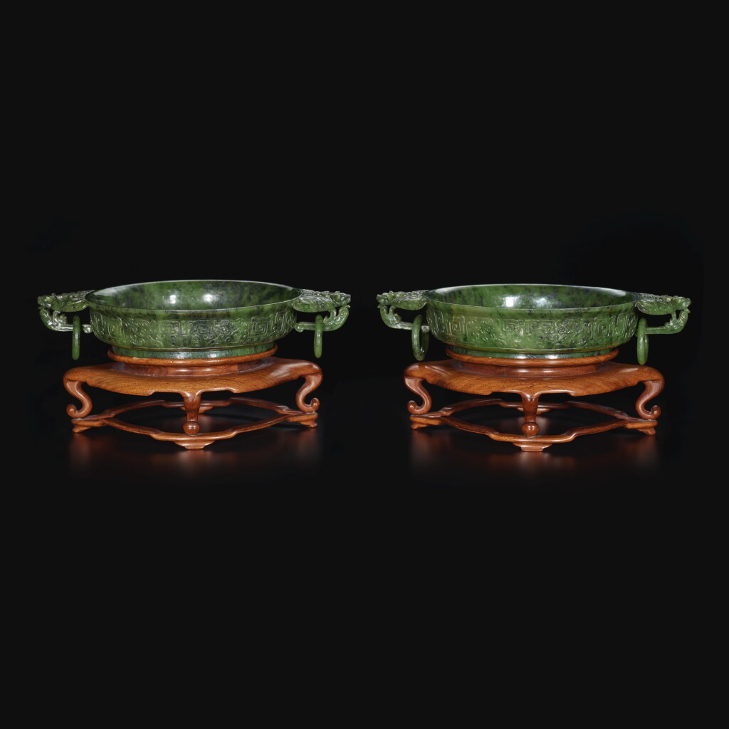 View full screen - View 1 of Lot 22. A pair of spinach-green jade shallow bowls, Qing dynasty, 19th / 20th century | 清十九 / 二十世紀 碧玉雕仿古夔龍紋蝠耳活環洗一對.