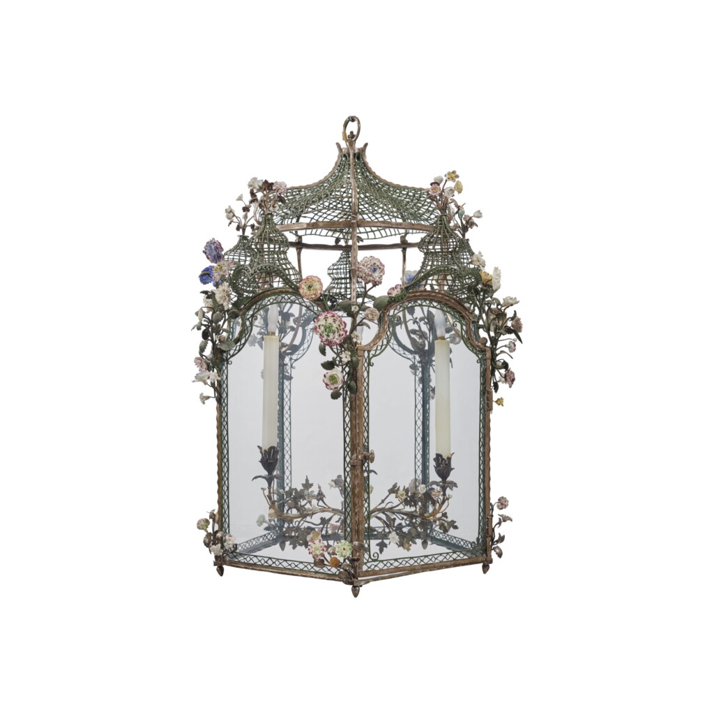 Voir en plein écran - Voir 1 du lot 87. A FRENCH LOUIS XV SILVERED BRONZE PENTAGONAL LANTERN DECORATED WITH CONTINENTAL PORCELAIN FLOWERS AND GREEN-PAINTED METAL TRELLISWORK, THE LANTERN MID-18TH CENTURY, THE FLOWERS AND METALWORK 18TH CENTURY AND LATER.