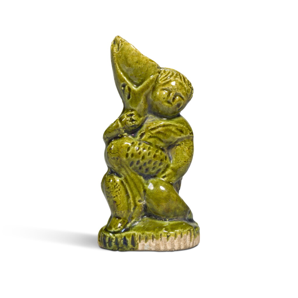 View full screen - View 1 of Lot 9. A rare miniature green-glazed 'foreign boy' wine vessel, Tang dynasty.