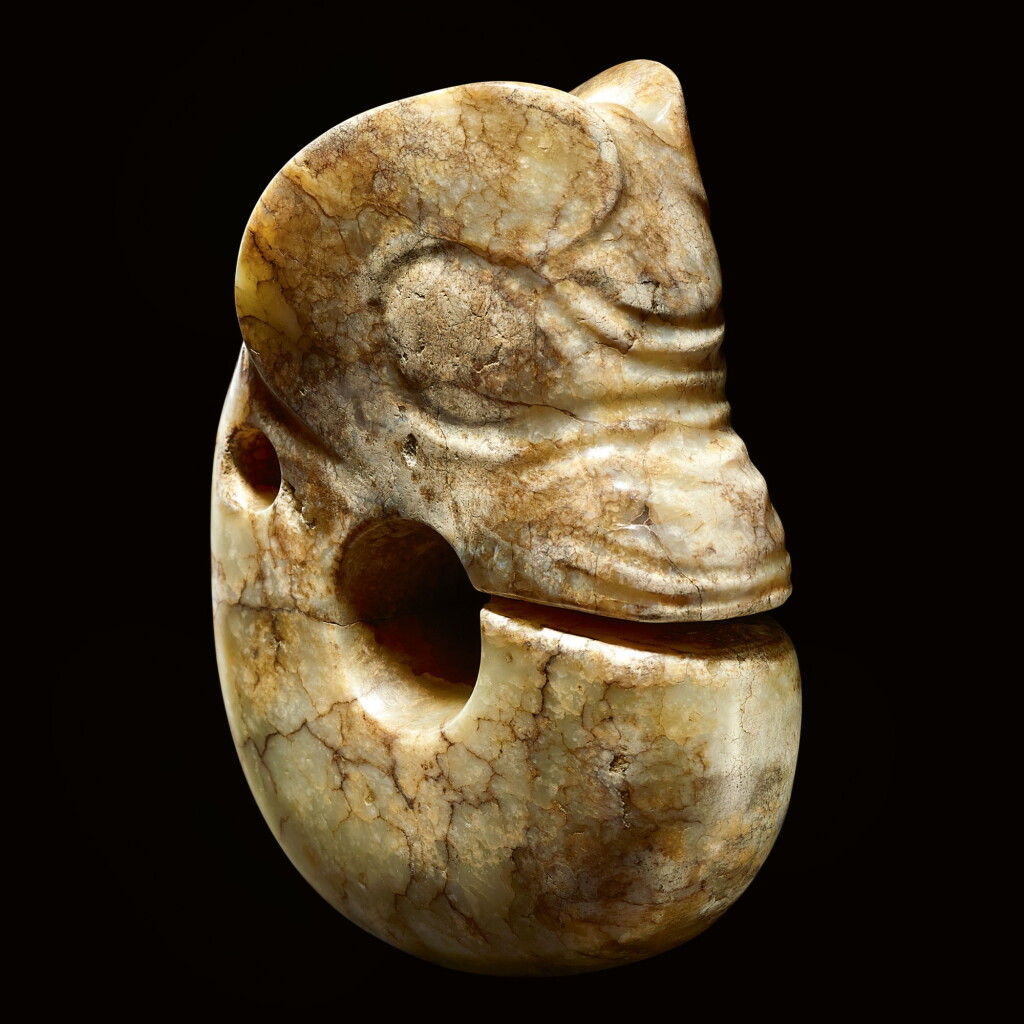 View full screen - View 1 of Lot 21. A RARE AND LARGE CALCIFIED YELLOW JADE ZHULONG ('PIG DRAGON') NEOLITHIC PERIOD, HONGSHAN CULTURE | 新石器時代紅山文化 黃玉豬龍.