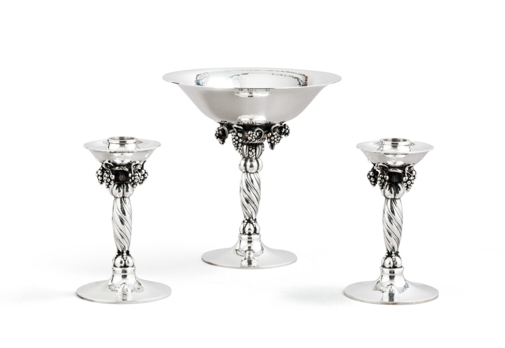 View full screen - View 1 of Lot 40. A Danish silver set comprising a bowl on foot ad a pair of candlesticks, Jensen, Copenhagen, 20th century | Ensemble en argent comprenant une coupe et une paire de flambeaux, par Jensen, Copenhague, XXe siècle.