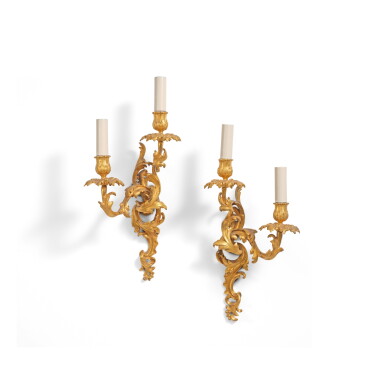View full screen - View 1 of Lot 540. A pair of Louis XV gilt-bronze two-light wall lights, circa 1750, in the style of Jacques Caffiéri.