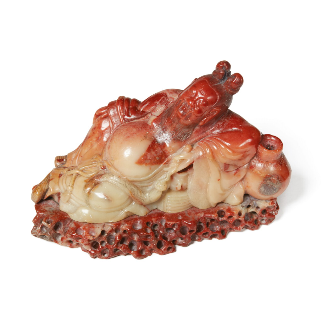 View full screen - View 1 of Lot 1045. A RED AND BEIGE SOAPSTONE CARVING OF LI BAI, QING DYNASTY, 19TH CENTURY.