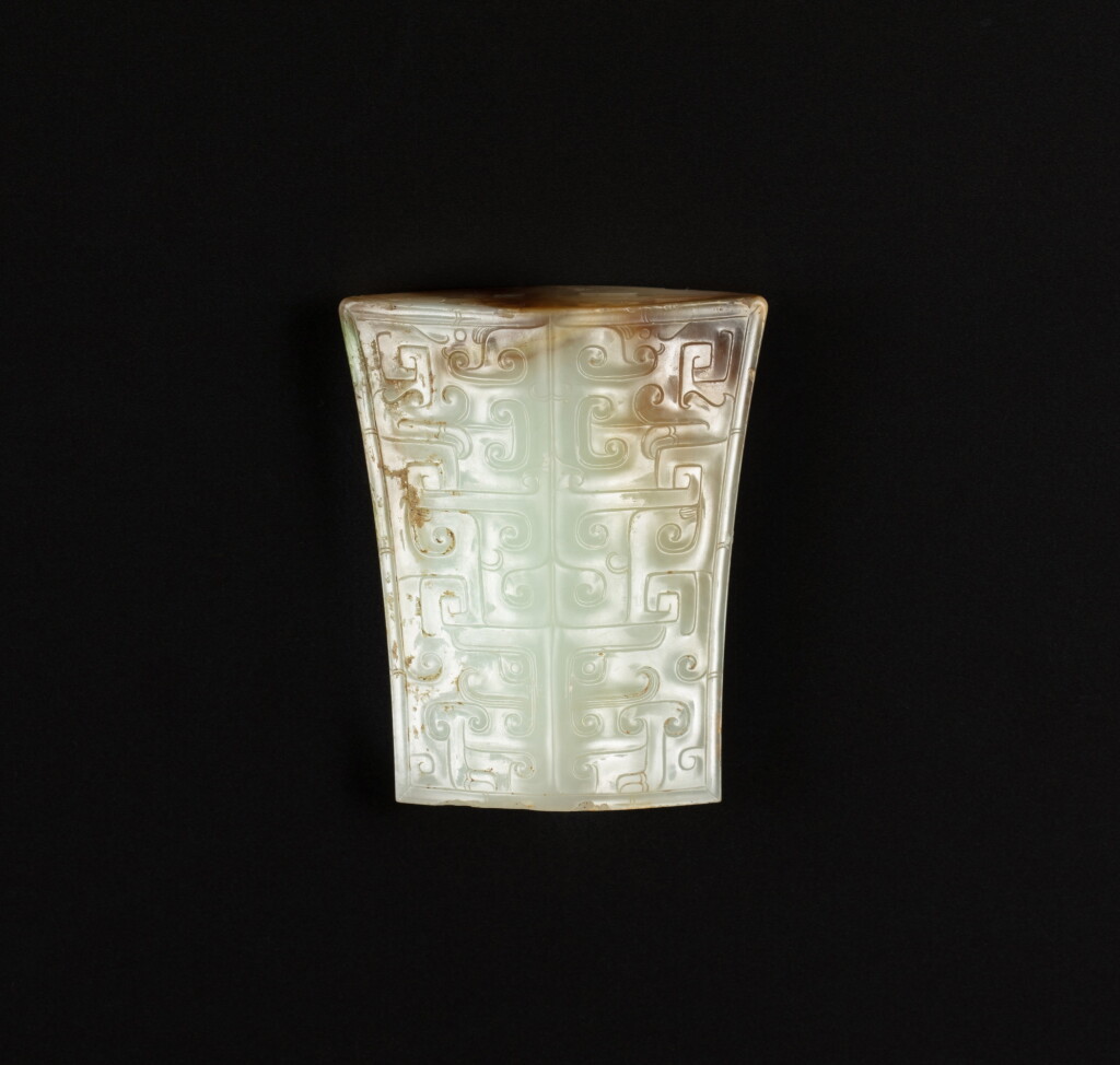 View full screen - View 1 of Lot 7. An archaic pale celadon jade 'mask' scabbard chape, Western Han dynasty, circa 2nd century BC | 西漢 約公元前二世紀 青白玉獸面紋劍珌.