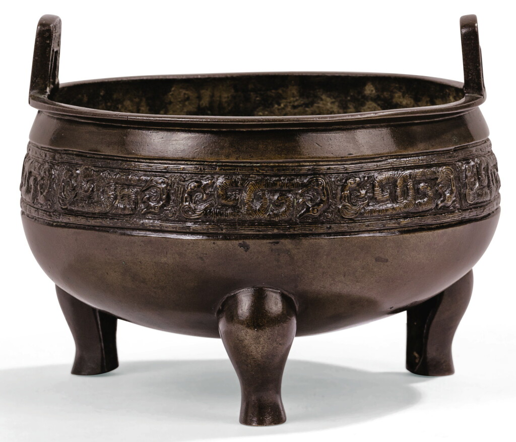 View full screen - View 1 of Lot 122. BRÛLE-PARFUM EN BRONZE DYNASTIE QING, XVIIIE SIÈCLE | 清十八世紀 銅仿古紋沖天耳三足爐 | A bronze tripod censer, Qing Dynasty, 18th century.
