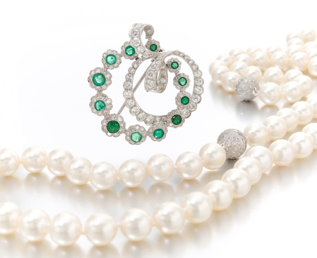 View full screen - View 1 of Lot 249. Pair of cultured pearl and diamond necklace and an emerald and diamond brooch (Paio di collana in perle coltivare e diamanti ed una spilla in smeraldi e diamanti).