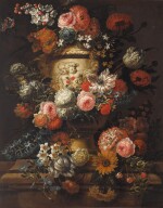 Carnations, peonies, tulips, morning glory and other flowers in a sculpted urn on a stone ledge