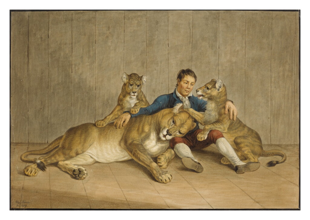 View full screen - View 1 of Lot 91. A man sitting with a lioness and her two cubs.