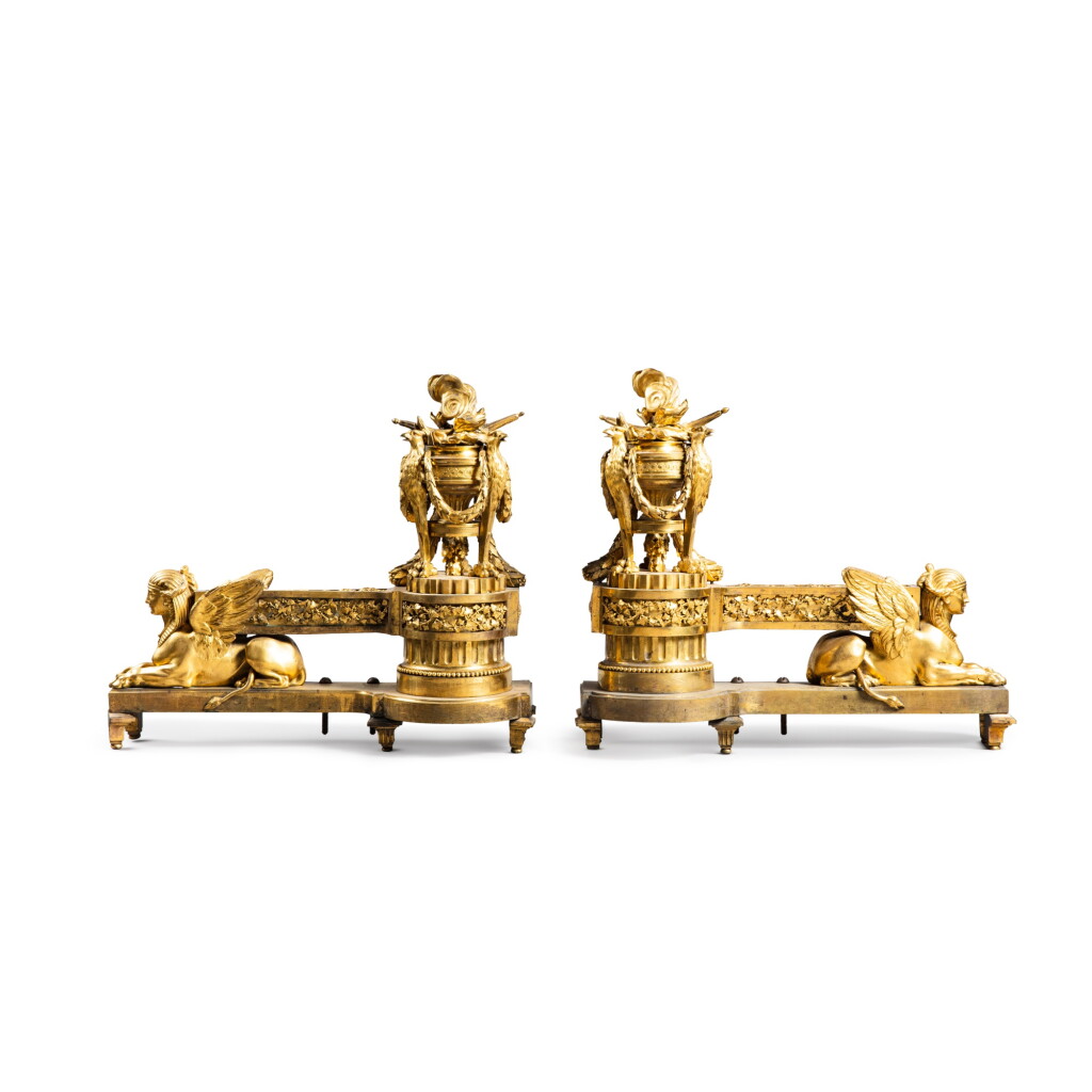 View full screen - View 1 of Lot 38. A pair of Louis XVI gilt-bronze fire dogs, circa 1785 | Paire de chenets aux sphinges ailées en bronze doré d’époque Louis XVI, vers 1785.