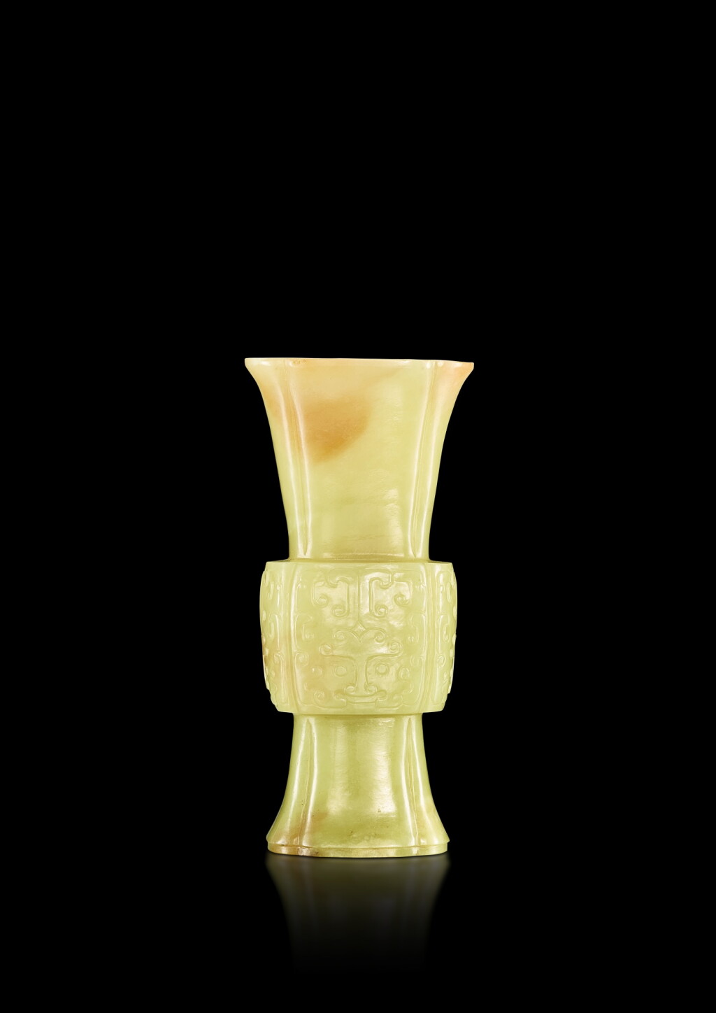 View full screen - View 1 of Lot 3645. A small yellow and russet jade 'taotie' gu vase, Qing dynasty, Qianlong period | 清乾隆 黃玉仿古饕餮紋海棠式花觚.