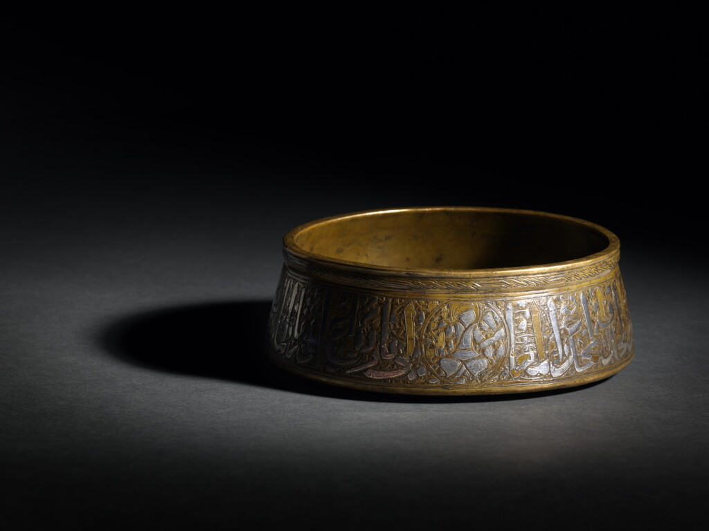 View full screen - View 1 of Lot 76. An early Mamluk silver-inlaid brass bowl featuring the personifications of the planets, Egypt, 14th century.