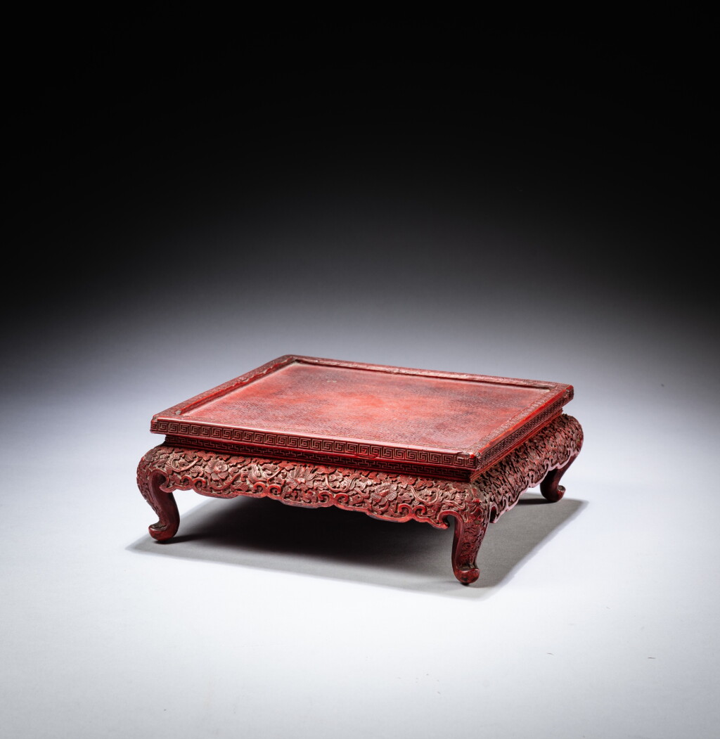 View full screen - View 1 of Lot 46. A small carved cinnabar lacquer table, Qing dynasty, 17th - 18th century | 清十七至十八世紀 剔紅花卉紋小方桌.
