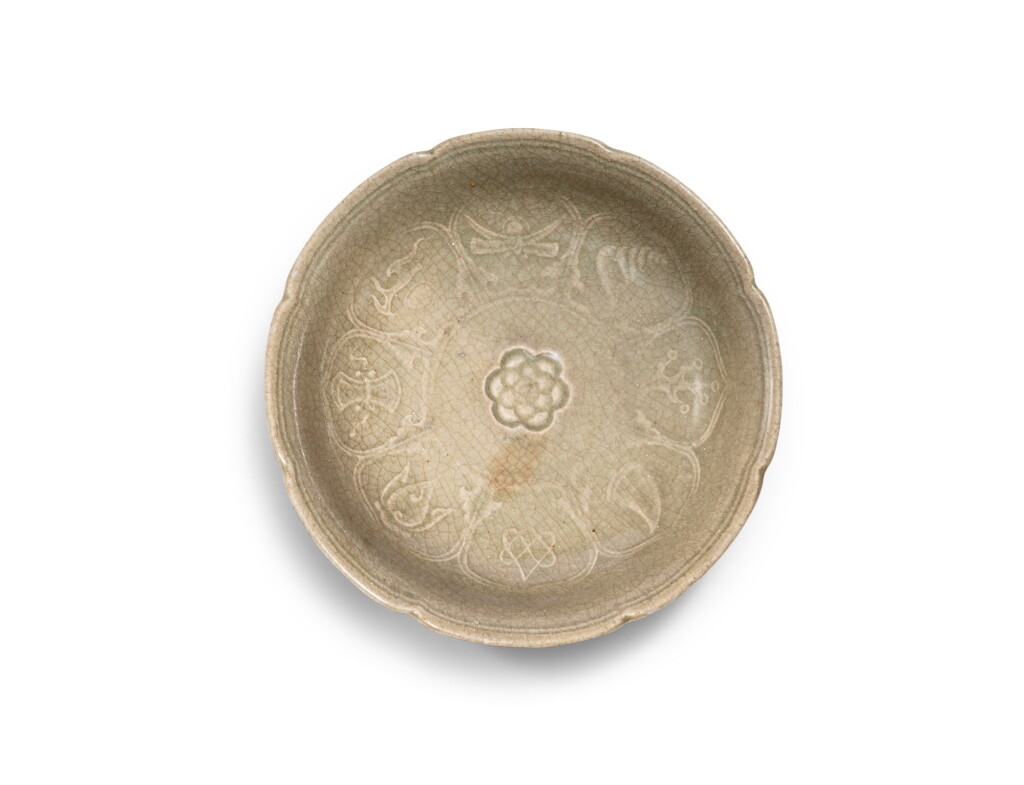 View full screen - View 1 of Lot 41. A rare lobed celadon 'auspicious objects' dish Yuan dynasty | 元 青釉印雜寶紋花口盤.